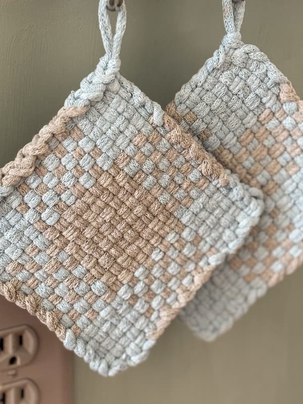 blue and gray woven pot holders hanging on hooks