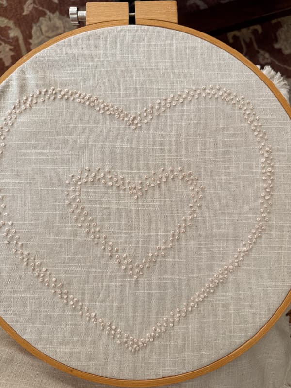 Double Heart Candlewick pillow cover in embroidery frame