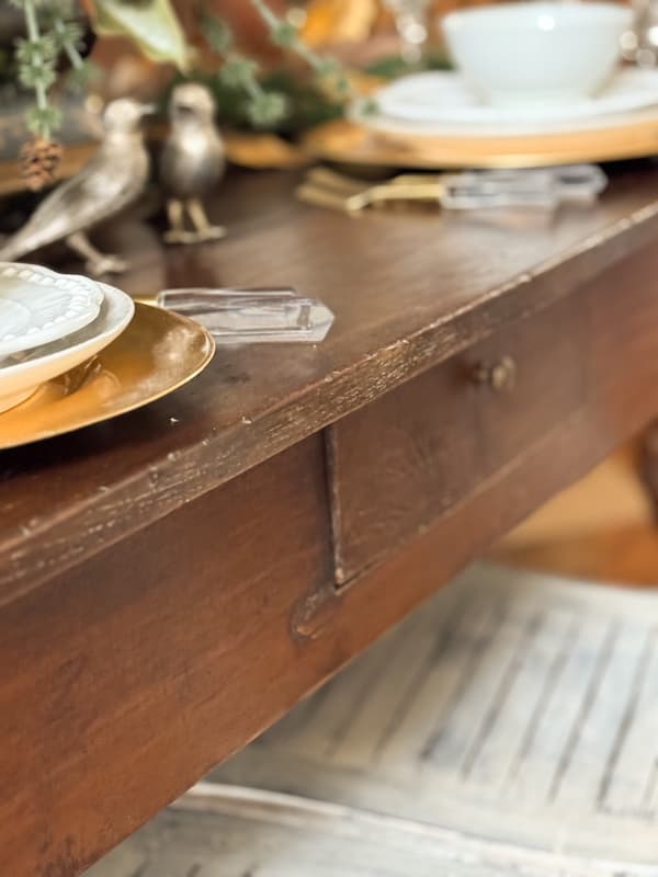 close up of antique dining table with scraches and dings.  Authentic aged patina for a curated home style