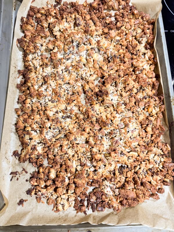 cooked granola on parchment lined baking sheet
