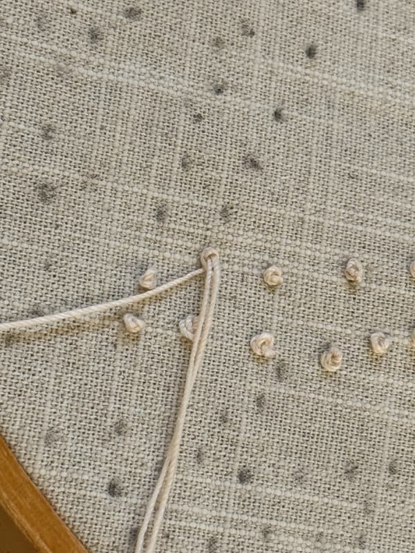 Draw thread through the fabric to form a knot for the candlewice stitch.  