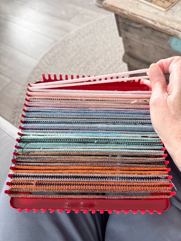 loop fabric strips over the weaving loom in line with each other