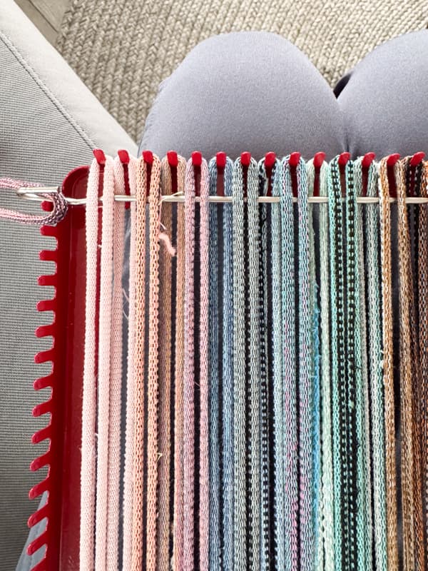 run hook over and under the fabric loops on the loom 