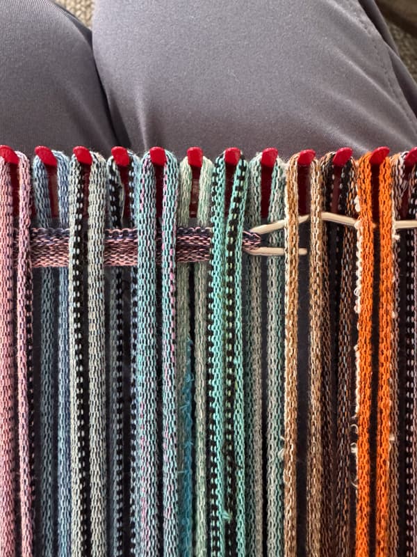 pull the loop through the ones already on the loom