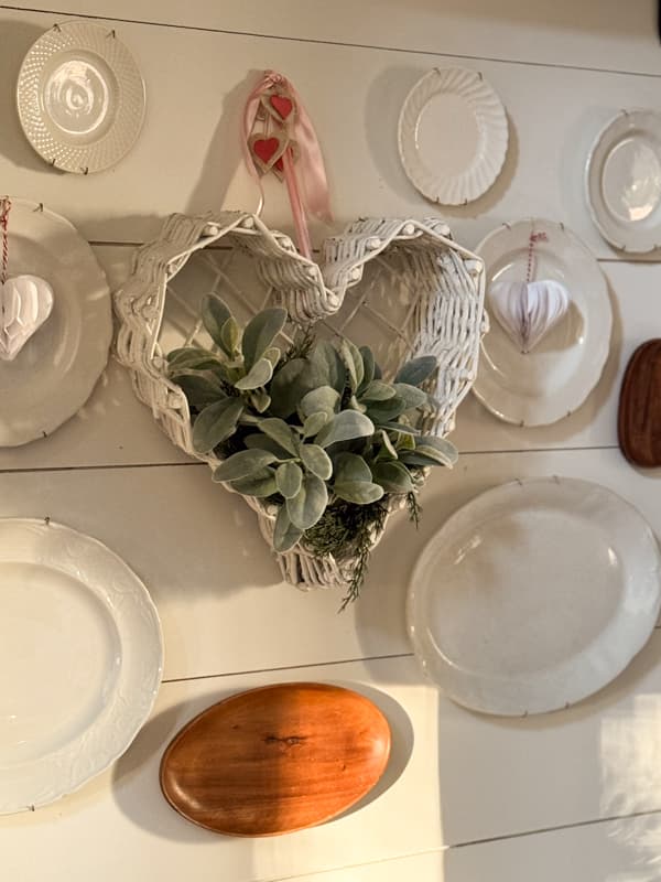 thrifted heart-shaped basket wall planter with lambs ear stems on plate gallery wall