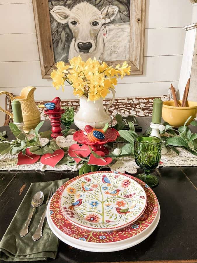 traditional red valentine tablescape with yellow daffodils and bird plates