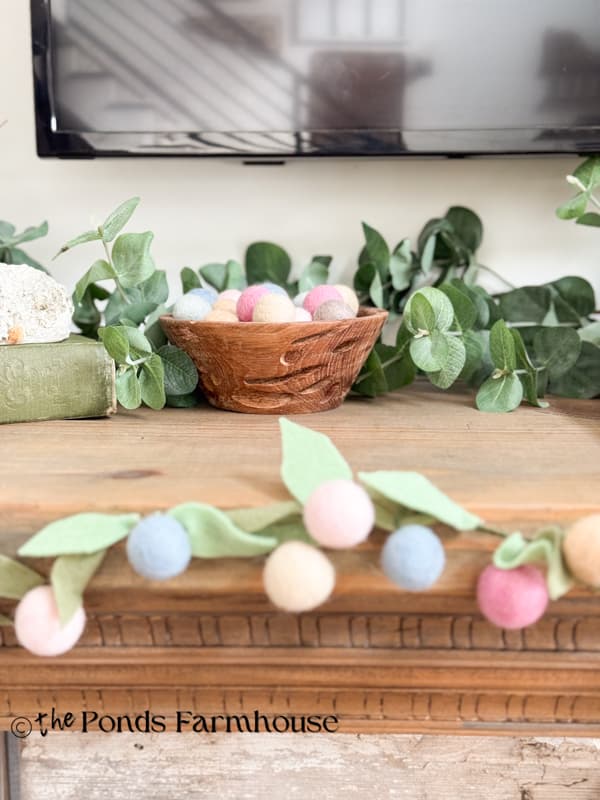 felt flower Spring Garland with wooden bowl of felt balls on the mantel