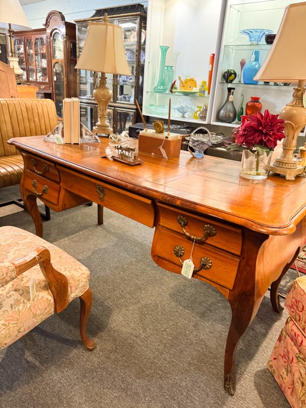 Secondhand French style desk and upholstered vintage chair at Consignment shop