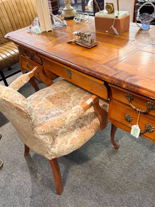 Secondhand French style desk and upholstered vintage chair at Consignment shop