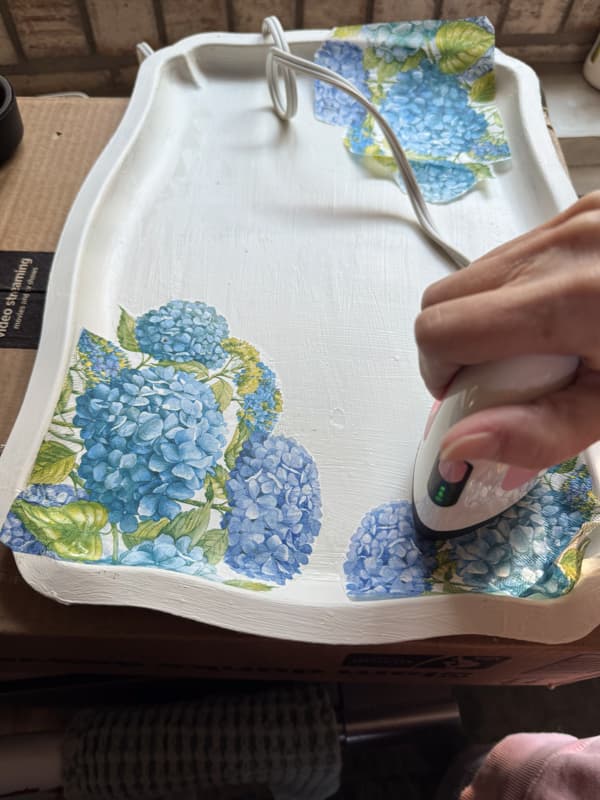 use mini heat press to adhere the napkins to the tray by activating the mod podge 