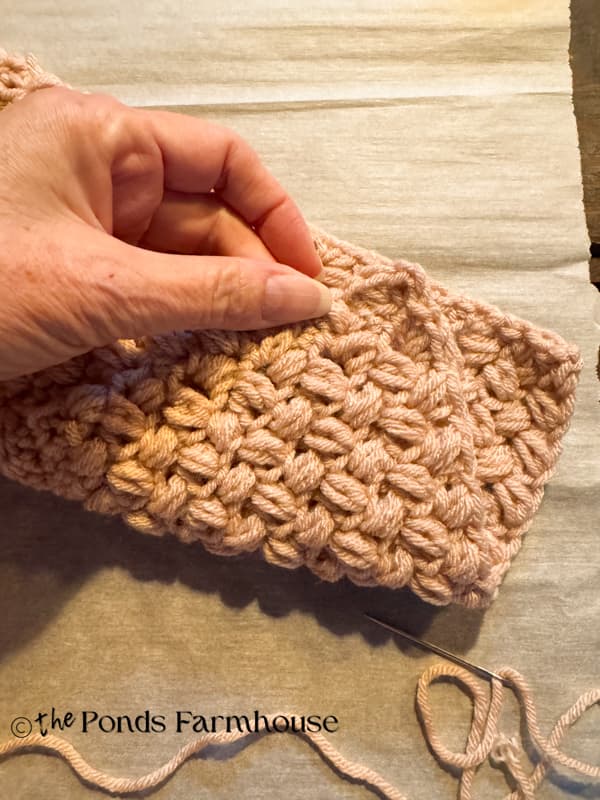 fold over corner of crochet scarf to create a triangle pocket
