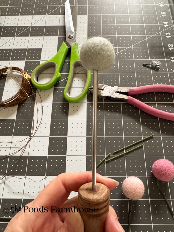 punch hole in wool felt ball with ice pick