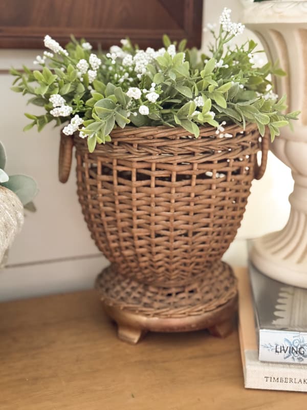 small wicker planter with greenery and white flowers