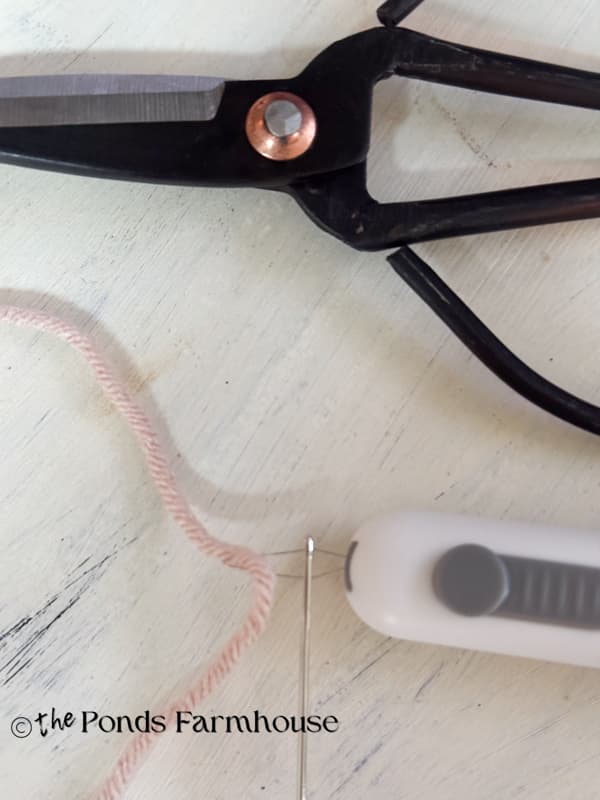 use needle thread to add yarn to embroidery needle.