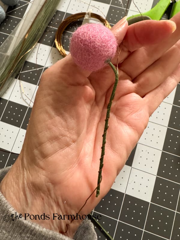 Wrap wire around the floral wire stem to secure to the garland