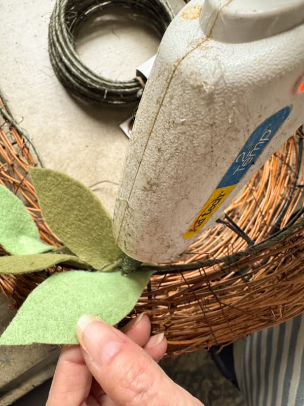 Add hot glue to the felt leaves to secure to the wreath wire