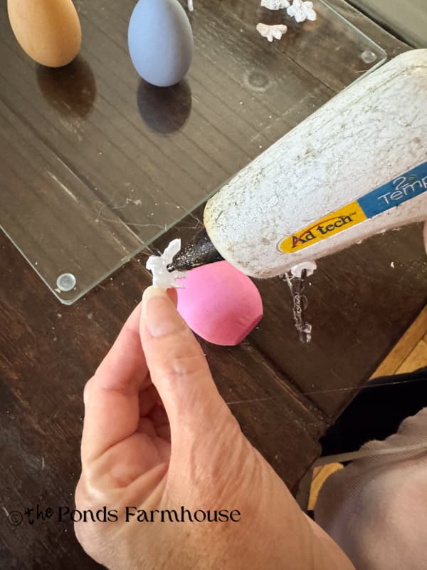 adding bee to wooden ;ink egg - DIY boutique style Easter Eggs with Hot Glue Bug Motifs