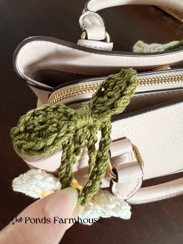 Adding purse charm to handle of handbag 