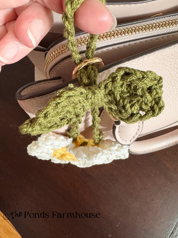 Adding purse charm to handle of handbag