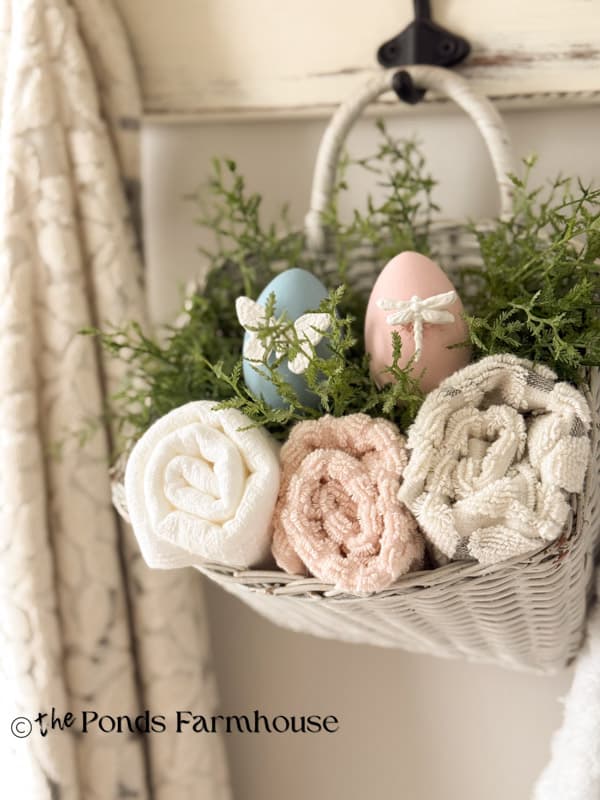 DIY High End Easter Eggs with Bug Motifs made with hot glue in wall hanging basket with towels