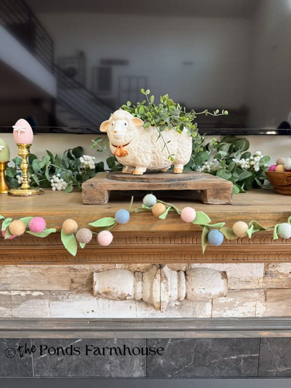 Easter Mantel with thrifted lamb planter, felt flower garland and greenery