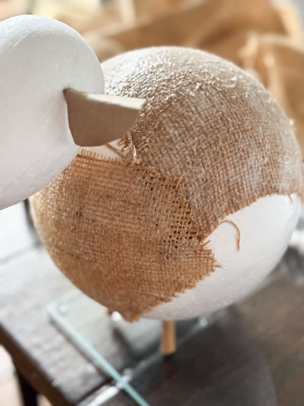 adding burlap with glue to the fat styrofoam lambs