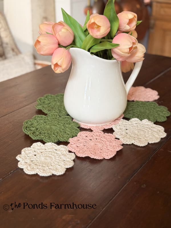 hand crochet doily table runner on rustic farmhouse table with ironstone pitcher & pink tulips