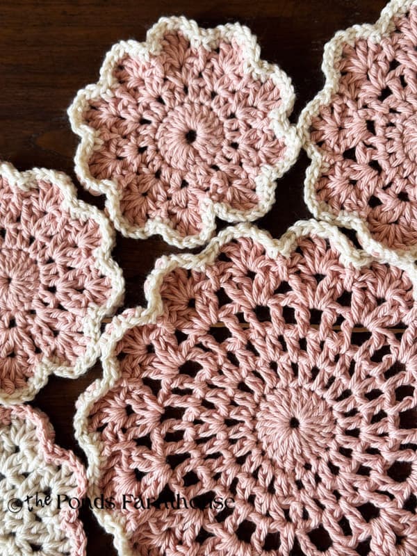 A round table runner with large and small doilies.  