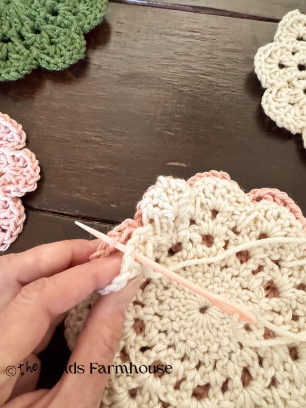 hand stitch doilies together at the points where they touch with yarn