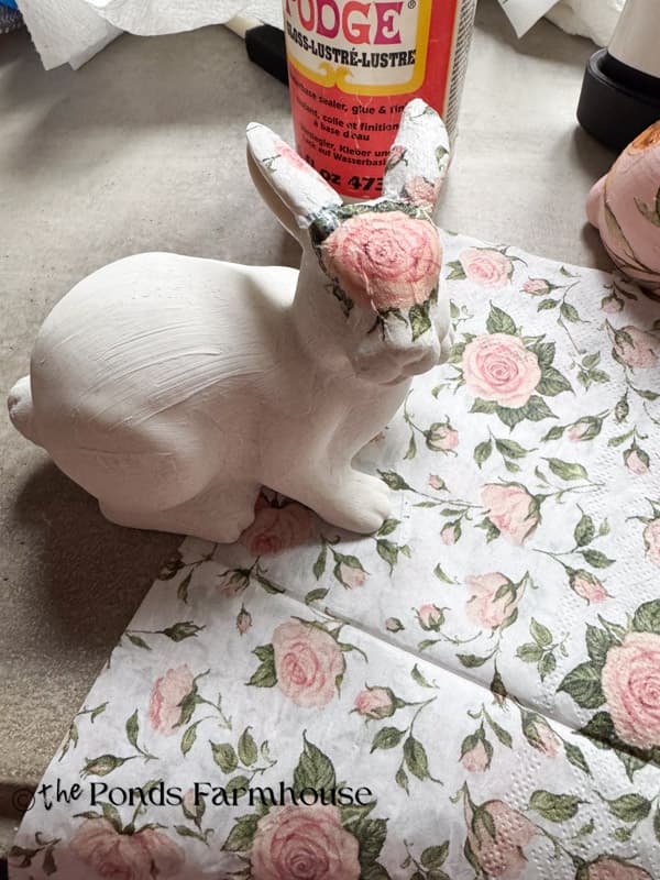 applying rose napkin to thrifted bunny for high end decor. 