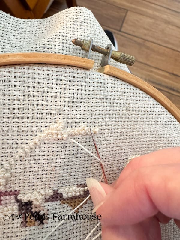 Wrap thread to the right and bring needle over and then back under the thread