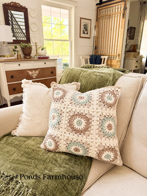 DIY Granny Square Pillow Cover on sofa with candlewick pillow.