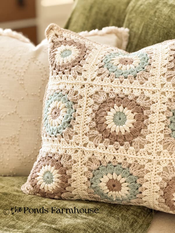 Close up of DIY Granny Square Pillow Cover on sofa