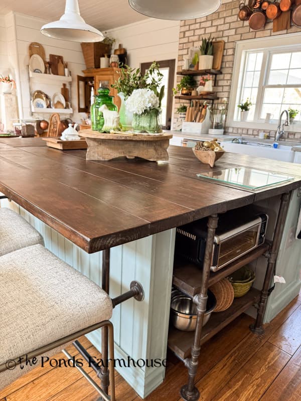 DIY kitchen island with natural wood countertop and industrial pipes