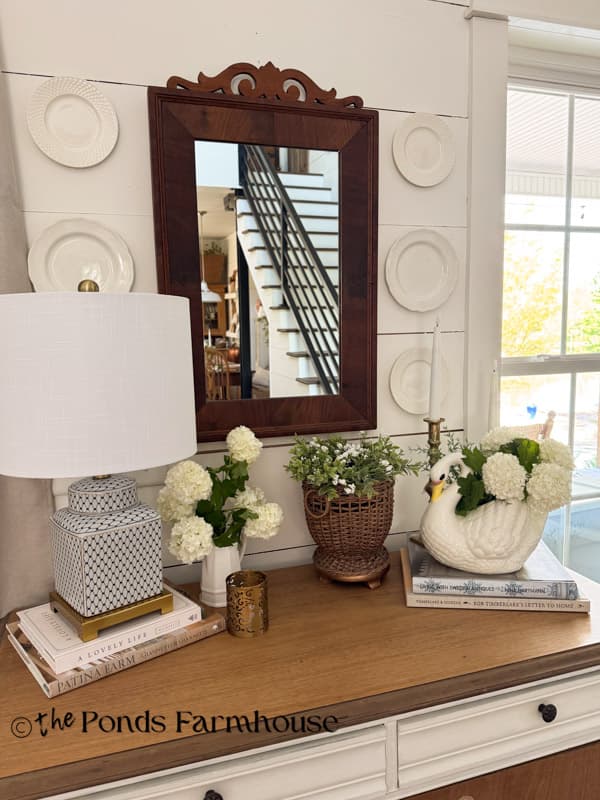 Entry table with swan planter filled will snowball blooms