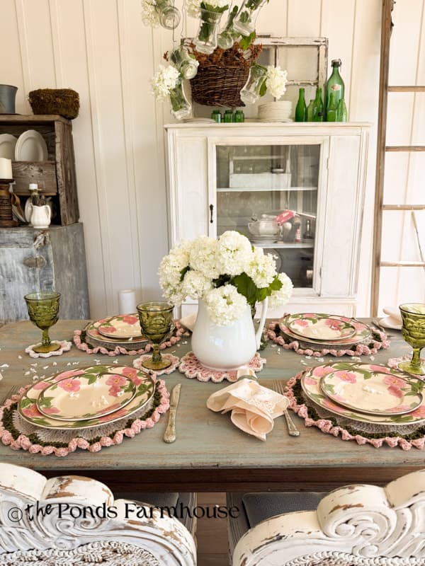 full table view of DIY vintage crochet placemats, vintage dishes and snowball centerpiece.  