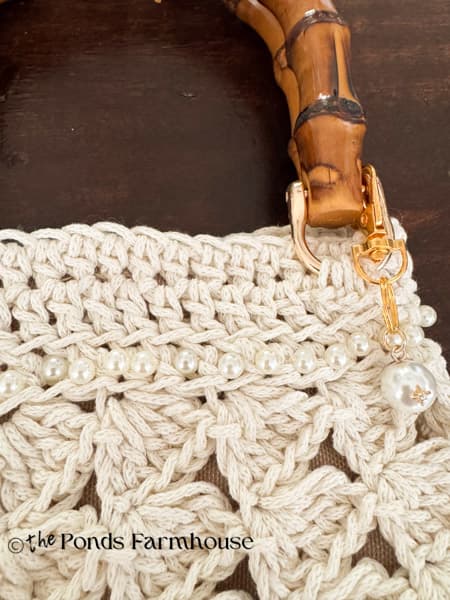 Attach handles with chain stitch and add pearl embellishments