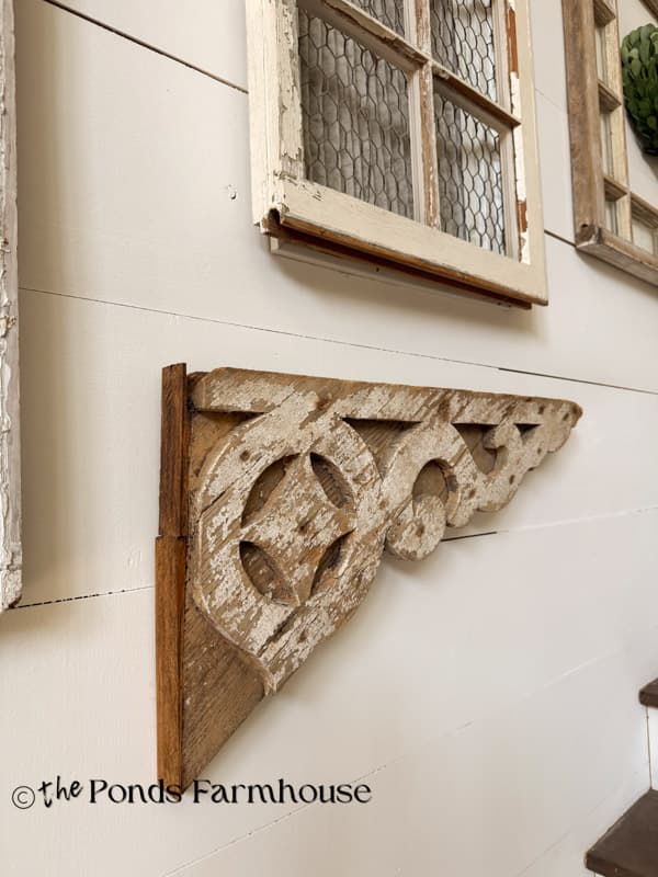 Antique fretwork mixed with old windows on staircase gallery wall