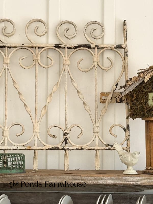Antique iron gate as art piece on cabinet on porch