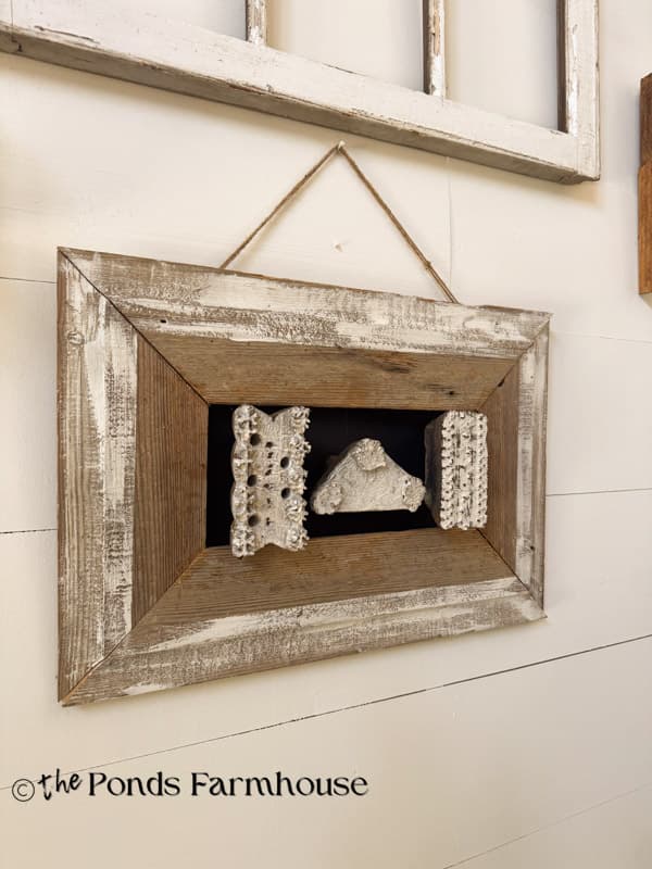 framed wallpaper stamps with salvaged shiplap board frame on gallery wall