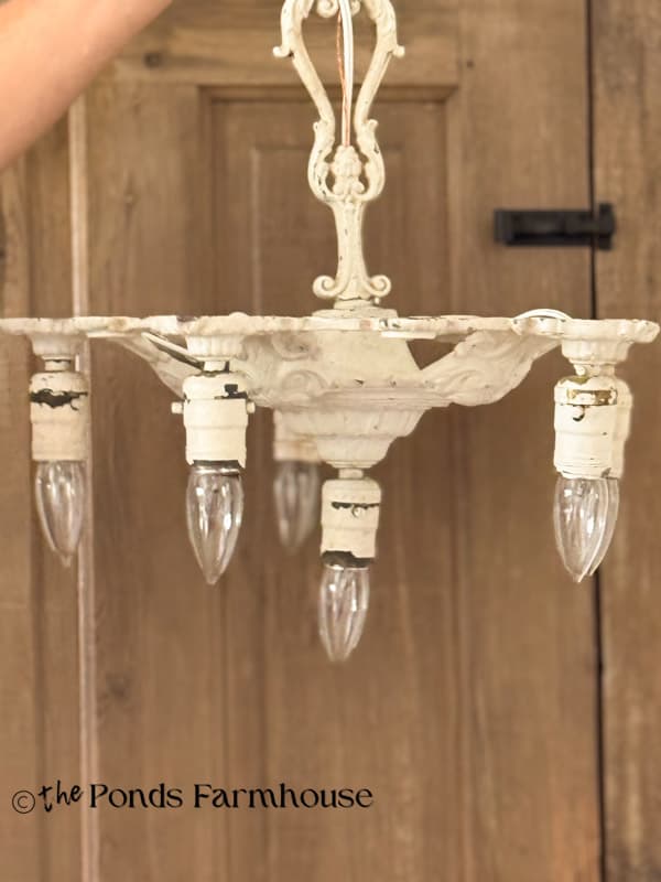antique chandelier with chippy white paint.