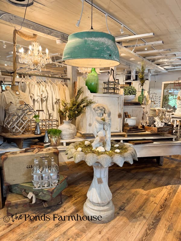 Displays and concrete cherub bird bath at Spring at the Farm pop-up show.