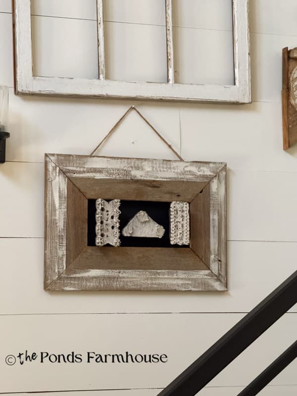 Gallery wall in stairway with old windows and Vintage Wall Paper stamps framed in old barn wood.