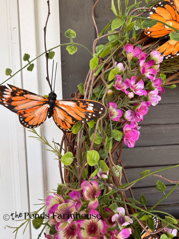 butterflies appear to be flying around the summer wreath.