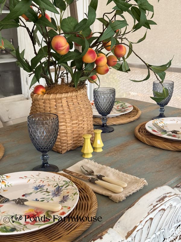 Peacg stems in a thrifted basket for summer tablescape centerpiece