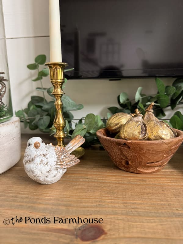 summer mantel with brass candlestick , bird and bowl with gold figs