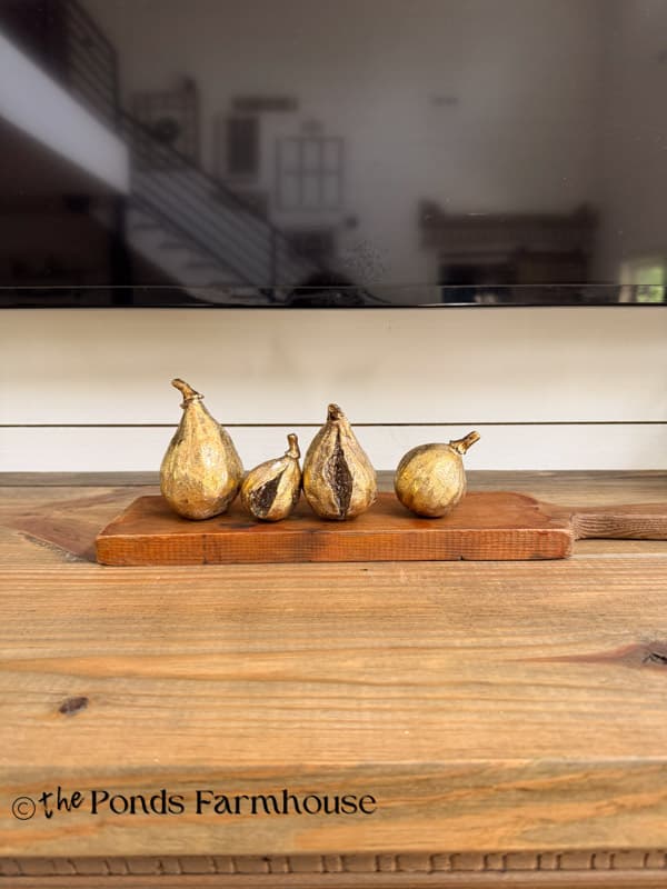 Summer mantel with wooden cutting board and gold figs