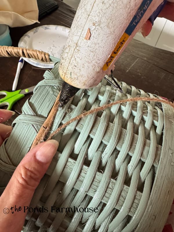 Add hot glue to adhere the jute twine around the basket