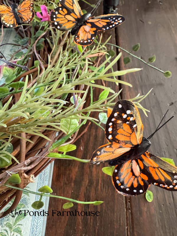 butterflies appear to be flying around the wreath.