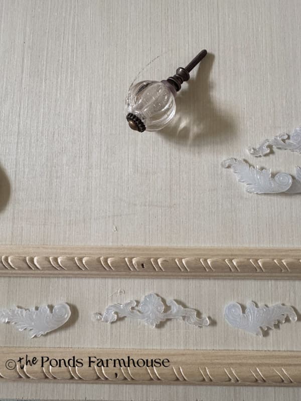 adding decorative trim made with hot glue to the fake drawer fronts